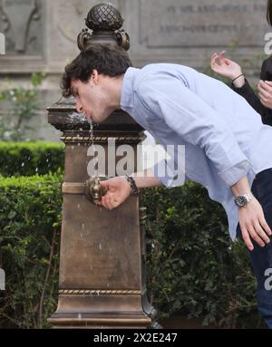 La persona si rifocillerà con acqua alla fontana in piazza Scala a Milano, Italia Foto Stock