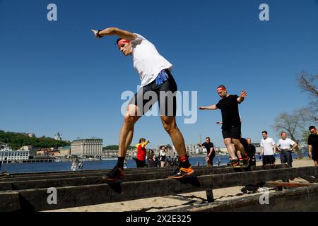 KIEV, UCRAINA - 20 APRILE 2024 - concorrenti in equilibrio sul trave durante la corsa di beneficenza spartana Kyiv 2024 sull'isola di Trukhaniv, Kiev, capitale dell'Ucraina. L'evento si tiene per raccogliere fondi per i droni per il personale dell'intelligence militare e un militare gravemente ferito dell'Intelligence della difesa dell'Ucraina. Foto Stock