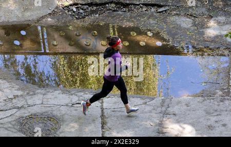 KIEV, UCRAINA - 20 APRILE 2024 - Una donna corre durante la corsa di beneficenza spartana di Kiev 2024 sull'isola di Trukhaniv, Kiev, capitale dell'Ucraina. L'evento si tiene per raccogliere fondi per i droni per il personale dell'intelligence militare e un militare gravemente ferito dell'Intelligence della difesa dell'Ucraina. Foto Stock