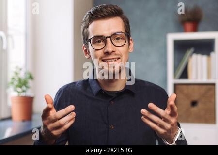 Un giovane insegnante online di freelance comunica con l'allievo del cliente tramite videoconferenza, telefonando su un computer portatile, tenendo lezioni online, lezioni e webinar a distanza. Visualizzazione webcam. Insegnamento online Foto Stock