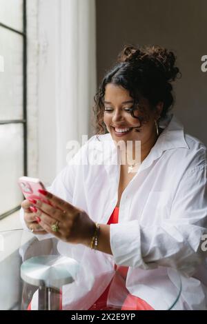 Donna felice guardando al telefono Foto Stock