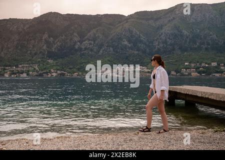 Donna che cammina su una spiaggia a Kotor Bay Foto Stock