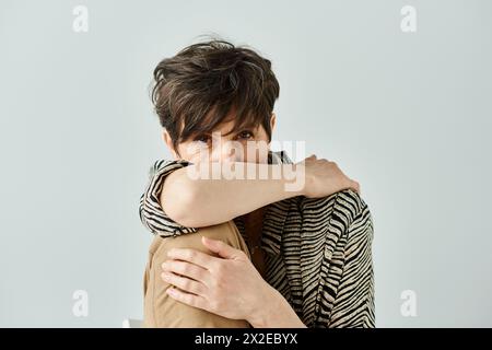 Una donna di mezza età con capelli corti e un abbigliamento elegante e profondo nel pensiero Foto Stock