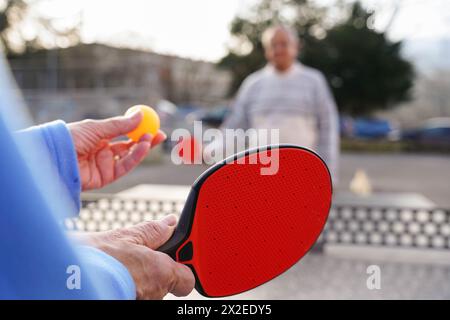 Coppia matura che gioca a ping-pong in giardino. Concetto di giochi olimpici Foto Stock