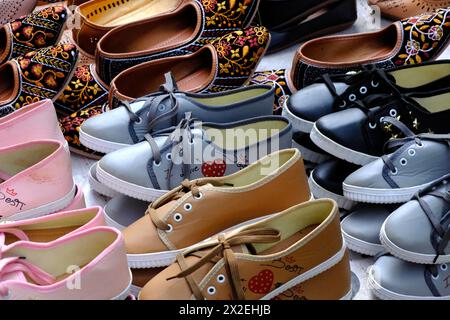 Colorate palle fatte a mano, scarpe (sandali) vendute in un mercato indiano, pantofole in pelle fatte a mano, calzature tradizionali. Foto Stock