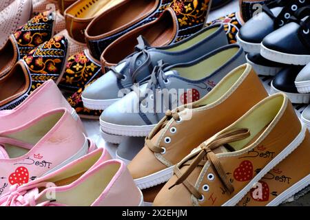 Colorate palle fatte a mano, scarpe (sandali) vendute in un mercato indiano, pantofole in pelle fatte a mano, calzature tradizionali. Foto Stock