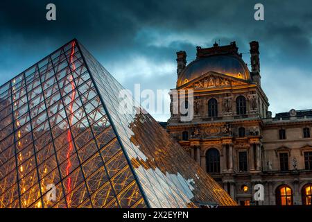 Crepuscolo sulla piramide di vetro del Louvre a Parigi. Foto Stock