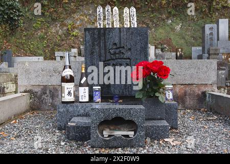 Kamakura, Prefettura di Kanagawa, Giappone, 11 dicembre 2010. La tomba del regista e sceneggiatore giapponese Yasujiro Ozu (1903-1963), nel cimitero Engaku-ji, uno dei più importanti complessi di templi buddisti zen in Giappone. La lapide di granito è contrassegnata solo da un singolo carattere kanji: L'ideogramma 無 - Mu - che non significa nulla, nulla, vuoto). Sulla tomba, condivisa con la madre, numerose bottiglie di sake e birra sono sempre lasciate come offerte dai visitatori in onore della passione del regista per l'alcol. ©Isabella De Maddalena/opale.Photo Foto Stock