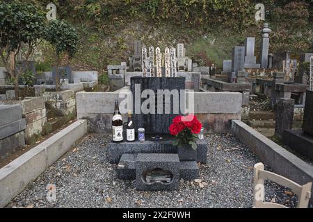 Kamakura, Prefettura di Kanagawa, Giappone, 11 dicembre 2010. La tomba del regista e sceneggiatore giapponese Yasujiro Ozu (1903-1963), nel cimitero Engaku-ji, uno dei più importanti complessi di templi buddisti zen in Giappone. La lapide di granito è contrassegnata solo da un singolo carattere kanji: L'ideogramma 無 - Mu - che non significa nulla, nulla, vuoto). Sulla tomba, condivisa con la madre, numerose bottiglie di sake e birra sono sempre lasciate come offerte dai visitatori in onore della passione del regista per l'alcol. ©Isabella De Maddalena/opale.Photo Foto Stock