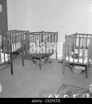 DAI BAMBINI D'AMERICA AI FIGLI D'INGHILTERRA: THE WORK OF KILRONAN NURSERY, WOKING, SURREY, INGHILTERRA, 1941 - Una vista del dormitorio del Kilronan Nursery, che mostra i bambini piccoli addormentati in culle di legno dai lati alti. Sotto i loro letti ci sono cesti contenenti i loro effetti personali. Questa fotografia è stata scattata nel mese di gennaio/febbraio 1941 Foto Stock