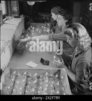 BOMBA APPICCICOSA: LA PRODUZIONE DELLA GRANATA No 74 IN GRAN BRETAGNA, 1943 - tre donne ispezionano le fiasche di vetro delle bombe appiccicose (No 74 ST Granades) in un'officina in Gran Bretagna. Da sinistra a destra sono: La signora F Hilton, la signora e Hall e la signora A Hooper. Secondo la didascalia originale, tutti hanno mariti nelle forze Foto Stock