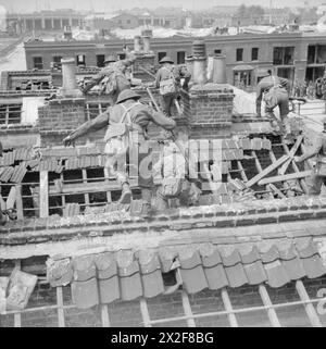 L'ESERCITO BRITANNICO NEL REGNO UNITO 1939-45 - soldati che si arrampicano sui tetti frantumati durante l'addestramento ai combattimenti in strada in un'area bombardata nell'East End di Londra, 26 giugno 1942 Foto Stock