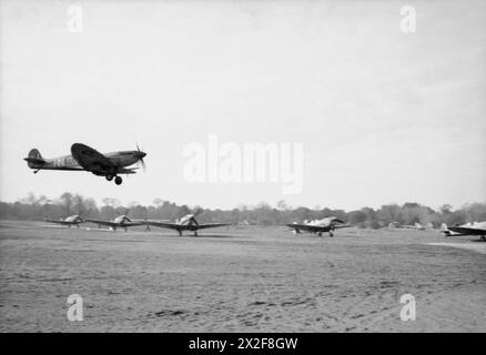 ROYAL AIR FORCE: ITALIA, BALCANI ED EUROPA SUDORIENTALE, 1942-1945. - Operazione SHINGLE: Sbarco alleato ad Anzio, Italia. Un Supermarine Spitfire Mark IX del No. 93 Squadron RAF arriva a terra presso lo sbarco Lago, vicino a Castel Volturno, dopo una pattuglia sopra la testa della spiaggia di Anzio, mentre altri Spitfire del No. 324 Wing RAF si allineano sulla pista, pronti a decollare dalla Royal Air Force, 93 Squadron, Royal Air Force, 324 Wing Squadron Foto Stock