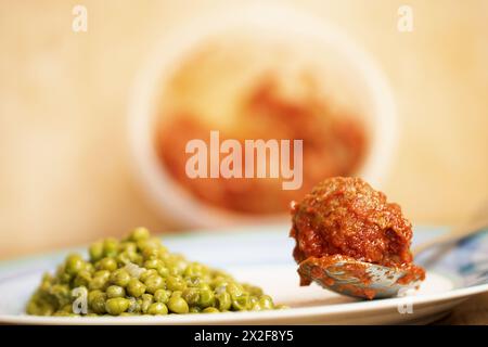 polpetta in salsa con un lato di piselli Foto Stock