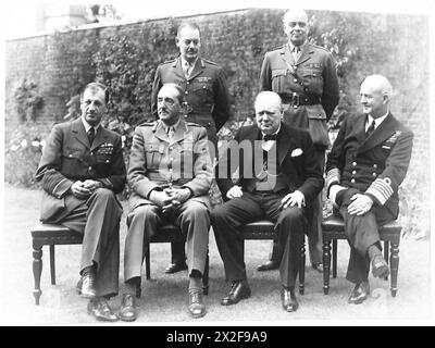 IL PRIMO MINISTRO INTRATTIENE I CAPI DI STATO MAGGIORE AL PRANZO AL N.10 DI DOWNING STREET - seduti - da sinistra a destra - Sir Charles Portal, Sir Alan Brooke RT. Winston Churchill e Andrew Cunningham. In piedi - da sinistra a destra - il maggiore generale L.C.Hollis [Segretario del Comitato dei capi del personale] e il generale Sir Hastings Ismay, [Capo di Stato maggiore del Ministro della difesa] British Army Foto Stock