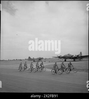In un aeroporto americano in Gran Bretagna nel 1943, il personale britannico e dell'US Army Air Corps utilizza biciclette per muoversi intorno alla base, passando più aerei tra cui uno del 326 Squadron, 92nd Bombardment Group. Foto Stock