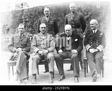 IL PRIMO MINISTRO INTRATTIENE I CAPI DI STATO MAGGIORE AL PRANZO AL N.10 DI DOWNING STREET - seduti - da sinistra a destra - Sir Charles Portal, Sir Alan Brooke RT. Winston Churchill e Andrew Cunningham. In piedi - da sinistra a destra - il maggiore generale L.C.Hollis [Segretario del Comitato dei capi del personale] e il generale Sir Hastings Ismay, [Capo di Stato maggiore del Ministro della difesa] British Army Foto Stock