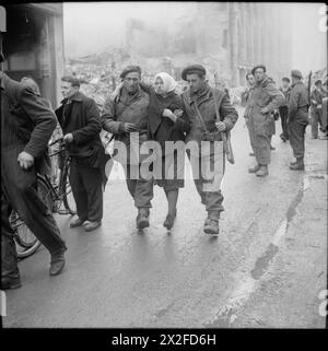 L'ESERCITO BRITANNICO NELL'EUROPA NORDOCCIDENTALE 1944-45 - i lavoratori russi liberati in schiavitù sono stati salvati da una cantina dopo che era stato dato alle fiamme da un poliziotto tedesco, Osnabruck, 7 aprile 1945, British Army Foto Stock