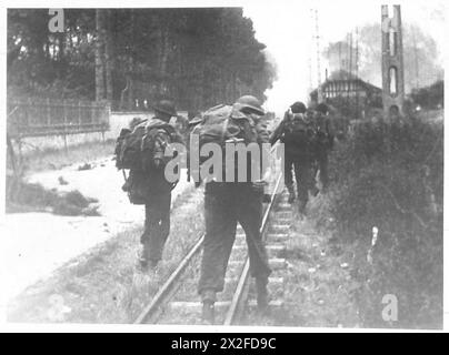 I Commandos del No. 4 Commando, 1st Special Service Brigade, si spostano lungo Rue de Riva-bella a Ouistreham durante gli sbarchi del D-Day, avvicinandosi a Sword Beach a bordo di un mezzo da sbarco il 6 giugno 1944. Foto Stock