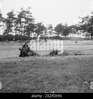 Un cecchino dimostra la posizione di fuoco prona di Hawkins accanto a un altro nella posizione standard presso la scuola di cecchini del 21st Army Group vicino a Eindhoven il 15 ottobre 1944. Foto Stock