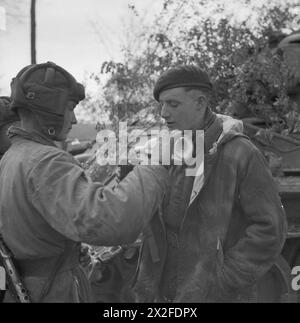 L'ingegnere reale Sapper Griffiths condivide un drink con un membro dell'equipaggio dei carri armati russi per celebrare il collegamento tra le forze britanniche e sovietiche nell'aprile-maggio 1945 durante la campagna alleata nell'Europa nord-occidentale. Foto Stock