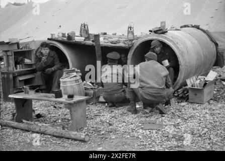 LIBERAZIONE DELLO STALAG 7A, MOOSBURG, GERMANIA - ex prigionieri di guerra nel loro rifugio improvvisato fatto di tubi di drenaggio in disuso Foto Stock