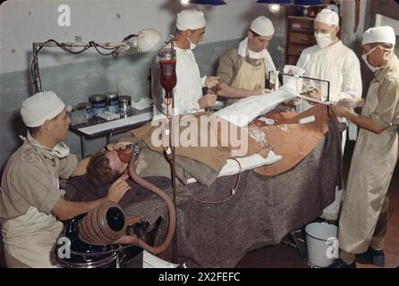 Un paziente ferito a una gamba riceve una trasfusione di sangue e una benda in gesso presso una stazione di medicazione avanzata in Italia. Trasfusioni di sangue vicino alla linea del fronte salvarono molte vite durante la seconda guerra mondiale. Foto Stock