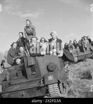 SOTTO FUOCO - COME RICOMPENSA: PRODUZIONE DI BOMBE MORTAI E TEST PRESSO LA J & F POOL'S NO 1 WORKS, HAYLE, CORNOVAGLIA, INGHILTERRA, 1943 - le lavoratrici di guerra della J & F Pool Ltd, una piccola fabbrica di armi del West Country, viaggiano verso un campo di prova in una portaerei Universal, Mark I. Sono stati premiati dal Ministero degli approvvigionamenti per aver prodotto 1 milione di bombe mortai con un viaggio per vedere alcune delle loro opere in azione Foto Stock