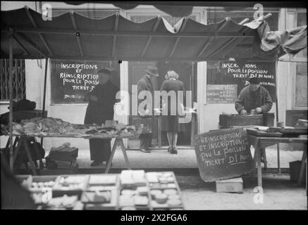 PARIGI, PRIMAVERA 1945: VITA DI TUTTI I GIORNI NELLA PARIGI LIBERATA, FRANCIA, MARZO 1945 - Una visione generale di una bancarella di pesci in un mercato, da qualche parte a Parigi. Secondo la didascalia originale, "il pesce è razionato su un complicato sistema di biglietti mensili. Quando sei registrato correttamente e hai ottenuto il biglietto, il pesce non sempre c'è" Foto Stock