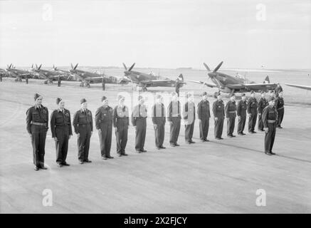 ROYAL AIR FORCE FIGHTER COMMAND, 1939-1945. - I piloti del No. 310 (Cecoslovacco) Squadron RAF sfilano davanti al loro Supermarine Spitfire LF Mark IXs all'aeroporto di Praga, al ritorno in patria. Da sinistra a destra: Josef Marsik; Karel Zouhar; Frantisek Masarik; Frantisek Vavrinek; Miroslav Liskutin DFC; Jindrich Skirka; Frantisek Vindris DFC; Frantisek Mlejnecky; Josef Sokol; otto Spacek; Jaroslav Dobrovolny; Karel Slama; Jaromir Strihavka; Vladimir Palicka; Karel Stryk; Bohuslav Velvarsky; Josef Rupprecht. Sul fronte si trova Otmar Kucera DFC Royal Air Force, Wing, 102 Foto Stock