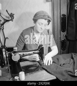 MEND AND MAKE DO: CORSI DI SARTORIA A LONDRA, 1943 - la signora Bolton al lavoro su una macchina da cucire durante un corso di Make Do and MEND nell'ufficio della filiale di Kennington del Partito Laburista. Sta facendo un cappotto per sua figlia di 16 anni sulla macchina da cucire che ha comprato per la classe come parte del "Pool di attrezzature", a cui tutti i membri della classe contribuiscono Foto Stock