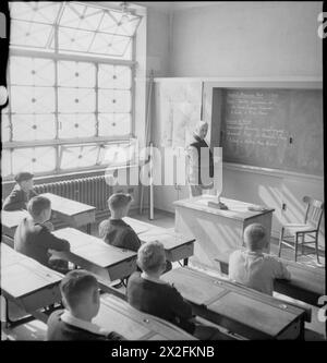 I GIOVANI BRITANNICI STUDIANO LA STORIA AMERICANA: EDUCAZIONE IN TEMPO DI GUERRA IN INGHILTERRA, 1943 - i ragazzi della Albany Senior School si siedono tranquillamente e ascoltano il loro insegnante il signor A B Culwell dà loro una lezione sull'America e sulla guerra ispano-americana. Secondo la didascalia originale, il signor Culwell una volta era un maestro di scuola della Royal Navy e visitava molti porti e città americani. Prendere nota del nastro adesivo incrociato sui finestrini per evitare danni da esplosione Foto Stock