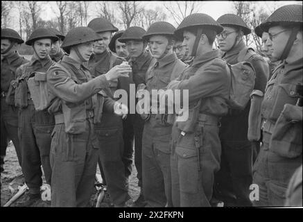 COMMANDOS BELGI IN ADDESTRAMENTO, Regno Unito, 1945 - Un caporale Lance dimostra il modo corretto di maneggiare una granata a mano a un gruppo di soldati belgi durante il loro addestramento Commando, da qualche parte in Gran Bretagna Foto Stock