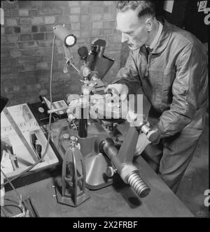 LABORATORIO FISICO NAZIONALE: SCIENZA E TECNOLOGIA IN TEMPO DI GUERRA, TEDDINGTON, MIDDLESEX, INGHILTERRA, REGNO UNITO, 1944 - la Metrology Division del National Physical Laboratory si occupa di mantenere elevati standard di precisione per quanto riguarda le misurazioni, quali lunghezza, massa e volume. Qui uno scienziato sta testando una macchina che è stata progettata per misurare il diametro di calibri ad anello semplici e avvitati Foto Stock