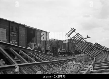 Nel marzo 1945, a seguito dei raid aerei alleati a Coesfeld, in Germania, i civili tedeschi furono fotografati saccheggiando i cantieri ferroviari danneggiati. L'immagine cattura le conseguenze immediate del bombardamento, mostrando i civili in mezzo ai relitti. Questa fotografia fa parte della serie CL dell'Air Ministry ed è conservata nella collezione Imperial War Museums. Foto Stock