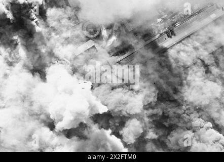 Una fotografia aerea verticale mostra un attacco alla luce del giorno a basso livello su acciai e armamenti a Denain, in Francia, nel 1943 da Douglas Boston Aircraft dal n. 88, 342 (francese libero) e 107 Squadron RAF, guidati dal Wing Commander G.R. England. Le bombe esplosive producono denso fumo sulla fabbrica di ferro-lega della Societe Francaise de Constructions Mecaniques. Foto Stock