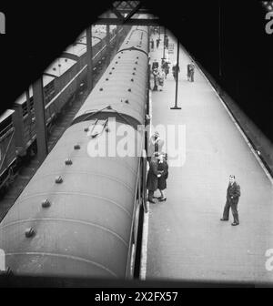 I passeggeri salutano sulla banchina della stazione di Euston, Londra, nel 1944 durante la guerra, con un treno in attesa accanto alla banchina. Foto Stock