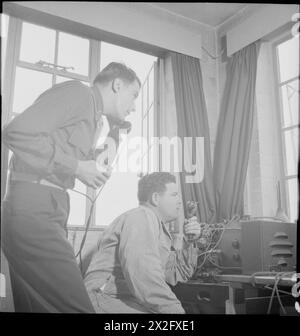 Il tenente Ernest W. Wagner e il sergente C.D. Doughty gestiscono apparecchiature nella torre di controllo di un aeroporto americano in Gran Bretagna durante il 1943, utilizzando un apparecchio di trasmissione RT britannico, un telefono e un binocolo. Foto Stock