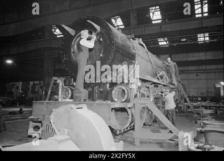 I lavoratori applicano i ritocchi finali a una locomotiva di classe 15F della South African Railways, costruita in una fabbrica di locomotive in Gran Bretagna nel 1945. Foto Stock