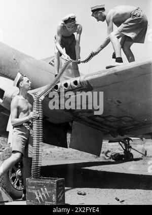 PRESSO LA HMS RAJALYIA, ROYAL NAVAL AIR STATION A PUTTALAM, CEYLON. FEBBRAIO 1945, ATTIVITÀ E PERSONALE PRESSO LA STAZIONE. - Tre Armouratori di Birmingham che riarmano un Corsaro Chance-Vought. Da sinistra a destra: AM (o) C J Marshall, da Kings Heath; AM (o) J Taylor, da Smethwick, e AM (o) W Partridge, da Oakham Foto Stock