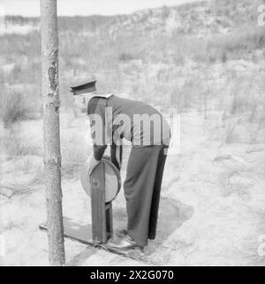 I MEMBRI DELLA ROYAL MERCHANT NAVY A SPARARE DURANTE IL LORO CORSO ANTIAEREO GUNNERY. 1941 - Mostra l'argano che sposta il bersaglio attraverso il raggio di tiro, utilizzato dalla Marina Mercantile durante il loro addestramento come cannoniere antiaereo Foto Stock