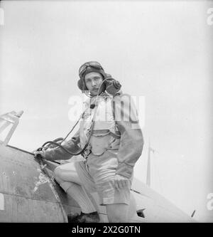 CECIL BEATON IN MEDIO ORIENTE FEBBRAIO-LUGLIO 1942 - Un pilota di caccia greco del No. 335 (Hellenic) Squadron Royal Air Force che indossa un casco volante presso la cabina di pilotaggio del suo Hawker Hurricane Mk 1 al Landing Ground 20, Qotafiaya i, a ovest di Daba, Egitto Foto Stock