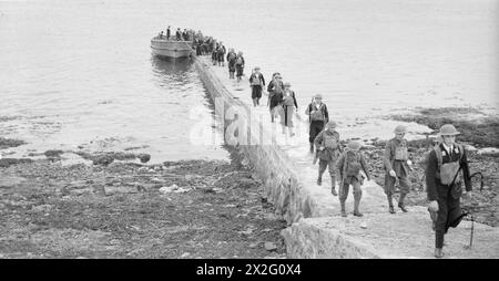 CON I ROYAL MARINES A TERRA E A GALLA. 1940, A BORDO DELLA HMS RODNEY E A TERRA. I VARI COMPITI SVOLTI DAI ROYAL MARINES. - I Marines e i marinai sbarcano in un punto tranquillo dalla loro barca Foto Stock