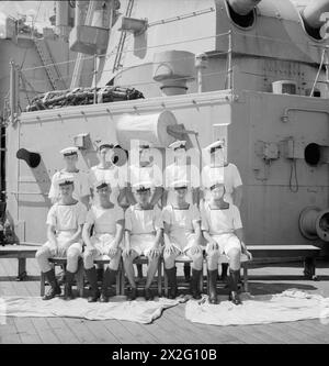 UOMINI DELLA HMS SUFFOLK, UN INCROCIATORE CHE SERVE CON LA FLOTTA ORIENTALE DELL'AMMIRAGLIO JAMES SOMERVILLE. 12 DICEMBRE 1943, TRINCOMALEE. GLI UOMINI SONO DIVISI IN GRUPPI PER CITTÀ E/O DISTRETTO. - Il gruppo Walthamstow. Fila anteriore, da sinistra a destra: AB C Dennett; L/Stoker A Mahoney; L/Stoker H Fidler; Stoker A Dean; AB H Griffen. Seconda fila, da sinistra a destra: AB A Newall, DSM, Sig B Pearce; po R Tuck; Coder F Tomlin; AB G Tweed Foto Stock