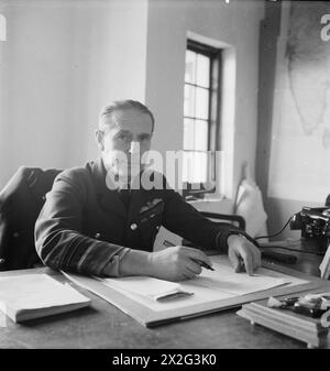 CECIL BEATON PHOTOGRAPHS: POLITICAL AND Military Personalities: Half length portrait of Air Chief Marshal Philip Joubert de la Ferte, Vice Capo di Stato maggiore per l'informazione e gli affari civili, South East Asia Command, seduto alla sua scrivania Joubert de la Ferte, Philip Bennet Foto Stock