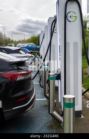 Auto presso la stazione di ricarica di veicoli elettrici, parte della rete Gridserve di punti di ricarica denominata Gridserve Electric Highway, Inghilterra Regno Unito Foto Stock