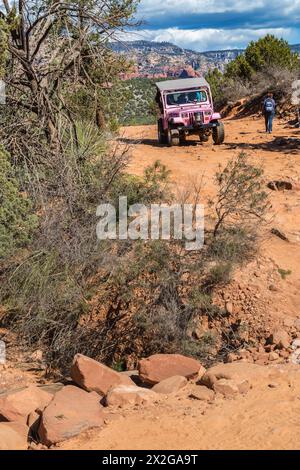 La jeep rosa della Pink Jeep Tours passa per gli escursionisti lungo la strada accidentata utilizzata dai veicoli fuoristrada a Sedona, Arizona Foto Stock