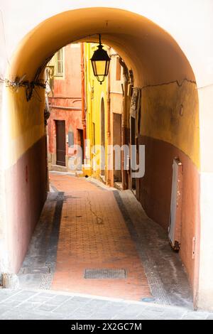 Arcade e una stretta strada della città vecchia di Mentone, Provenza, Francia, con facciate colorate Foto Stock