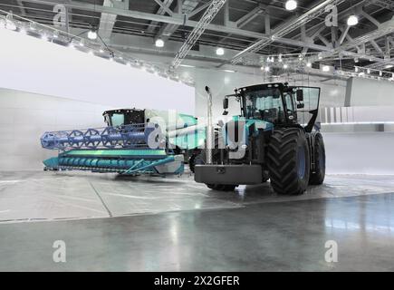 Grandi trattori e trebbiatrici sono in sala durante l'esposizione, macchine agricole speciali Foto Stock