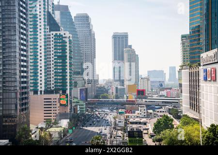 Guardando lungo Asoke Montri Road o Sukhumvit Soi 21 nella città di Bangkok, Thailandia. Lo skytrain BTS può essere visto lasciando la stazione di Asoke sullo sfondo. Foto Stock